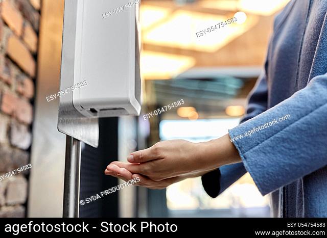 close up of woman at dispenser with hand sanitizer