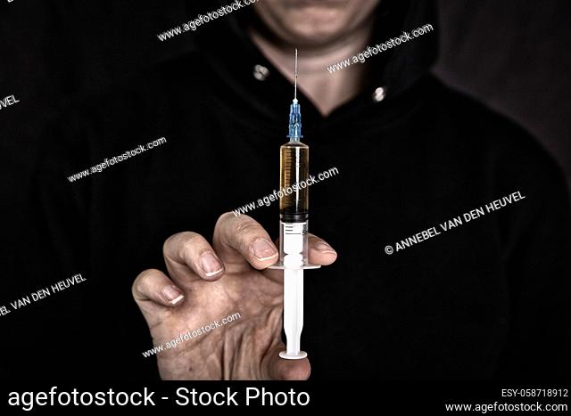 heroin addiction Junky shooting up Horse with syringe on dark background, Drugs, Junk, teen, addict concept portrait