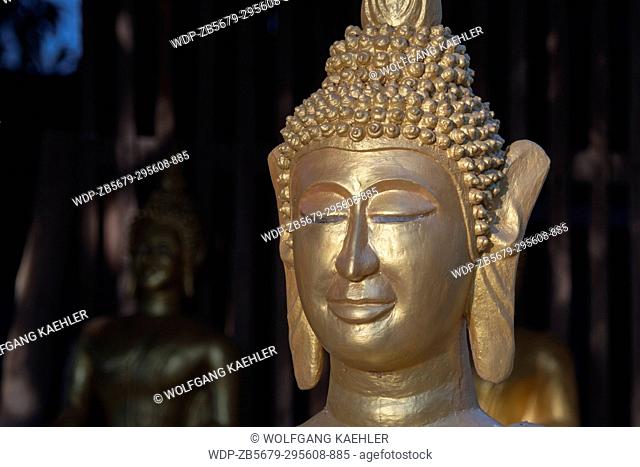 Detail of a guilded Buddha statue at Wat Xieng Muan (Xieng Muan Vajiramangalaram) a Buddhist temple in the UNESCO world heritage town of Luang Prabang in...