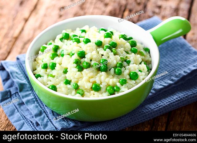 Fresh homemade creamy green pea risotto in green bowl (Selective Focus, Focus in the middle of the image)