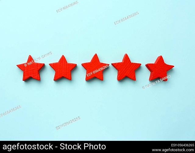 five red wooden stars on a blue background, high score, rating