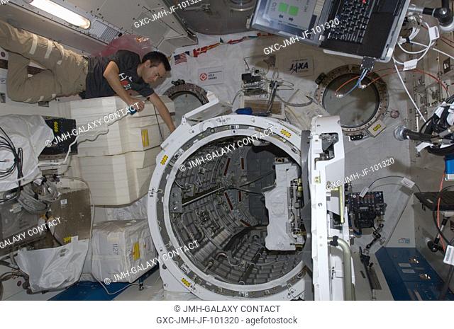 Japan Aerospace Exploration Agency astronaut Aki Hoshide, Expedition 32 flight engineer, talks on a microphone while working near the airlock in the Kibo...