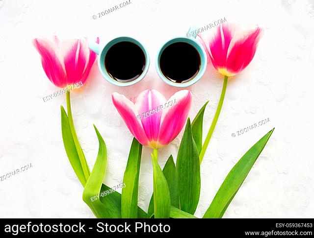 two cups of coffee and three beautiful pink tulips. valentine card