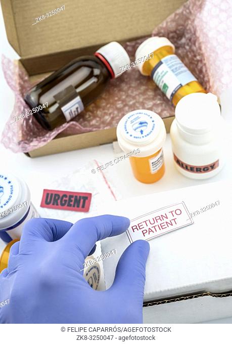 Nurse unpacking medication in boxes, pasting label return to the patient, conceptual image, composition vertical