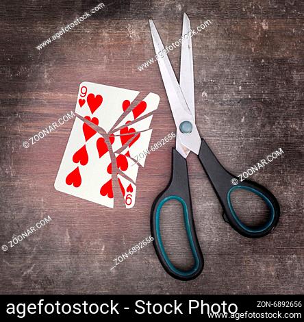 Concept of addiction, card with scissors, nine of hearts