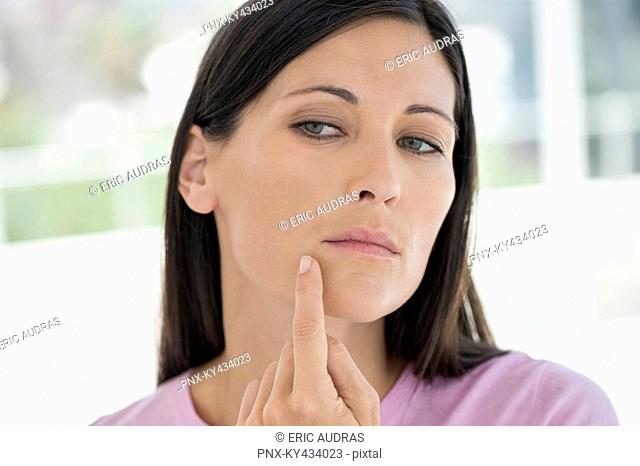 Woman checking wrinkles on her face