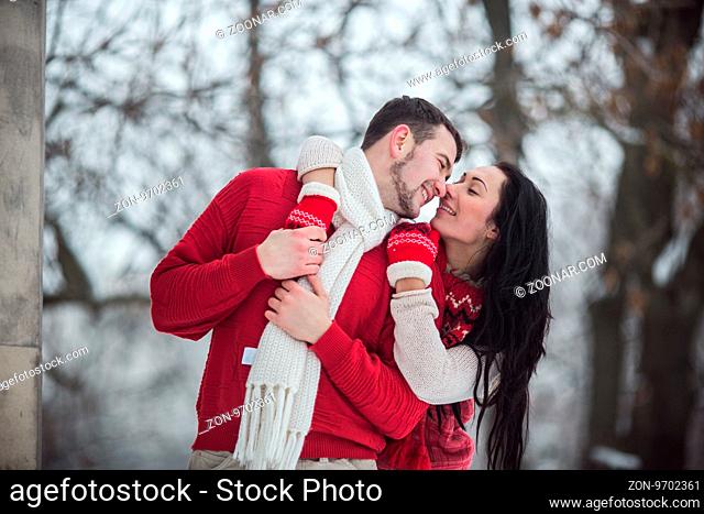 beautiful young couple posing in a snowy park, close view