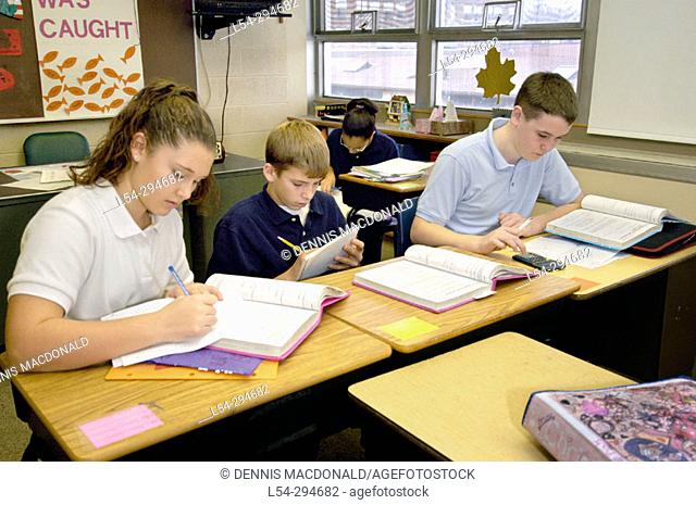 Seventh grade students learning maths by using calculators. Catholic school