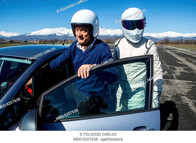 Actor and TV host Claudio Bisio and racing driver The Stig getting into a car in the backstage of the TV show Top Gear Italia. Italy, 1st March 2016