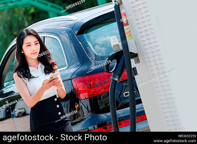 Young women use a mobile phone charging car buffet