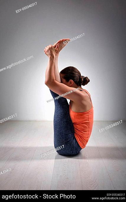 Sporty fit woman practices yoga asana Urdhva mukha paschimottanasana - upward facing intense west stretch