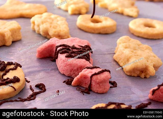 Pouring chocolate on just baked christmas cookies