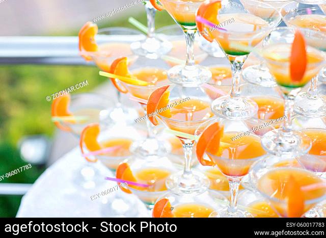 Pyramid from glasses at celebration. Colorful cocktails close up. an open-air party On the Sunset