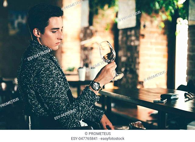 Handsome young man spends time in a wine restaurant