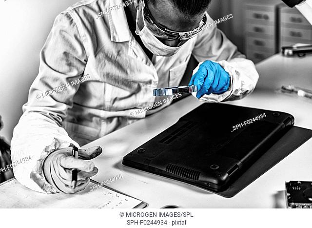Forensic Science Data. Forensic analyst examining laptop computer
