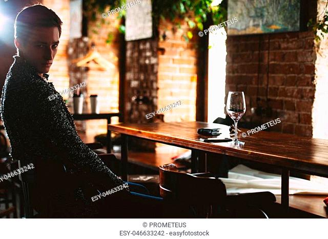 Handsome young man spends time in a wine restaurant