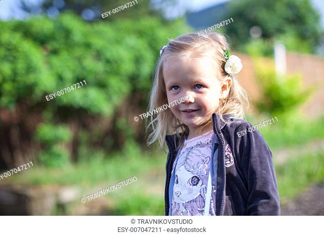 Cute little girl standing outdoo and laughting