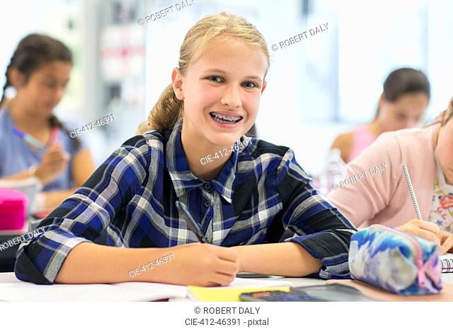 Portrait smiling, enthusiastic junior high school girl student with braces in classroom