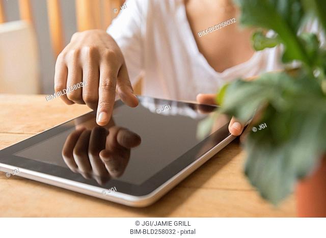 Hands of African American woman using digital tablet