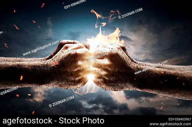 Close up of two fists hitting each other over dramatic sky background