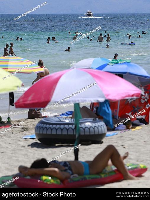 09 August 2022, Spain, Santa Margalida: People swimming and sunbathing on the beach of Can Picafort in Mallorca. Photo: Clara Margais/dpa