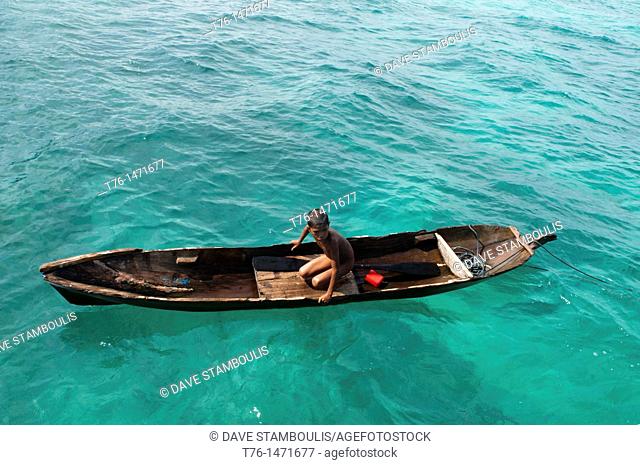 sea gypsy boy in his dugout canoe near Mabul Island, Borneo, Malaysia