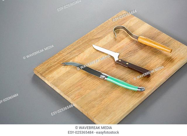 Cheese cutting tools on wooden board