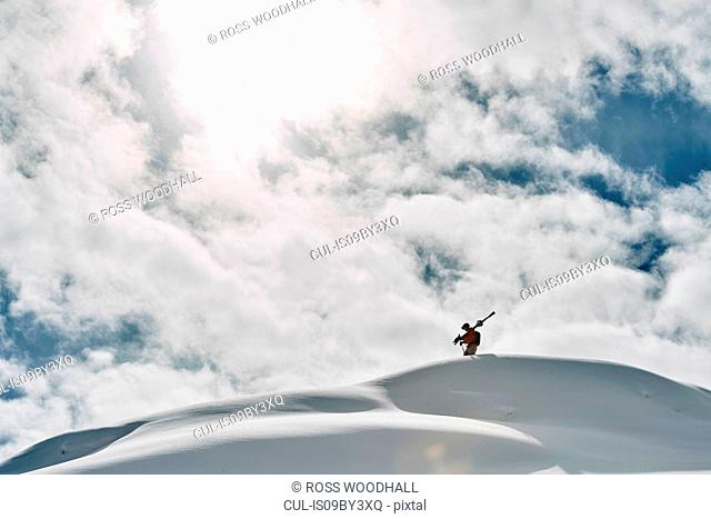 Male skier on top of snow covered mountain, Alpe-d'Huez, Rhone-Alpes, France