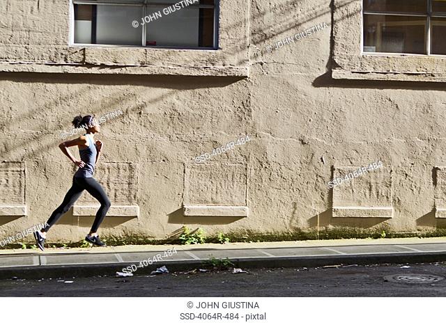 Woman jogging up street