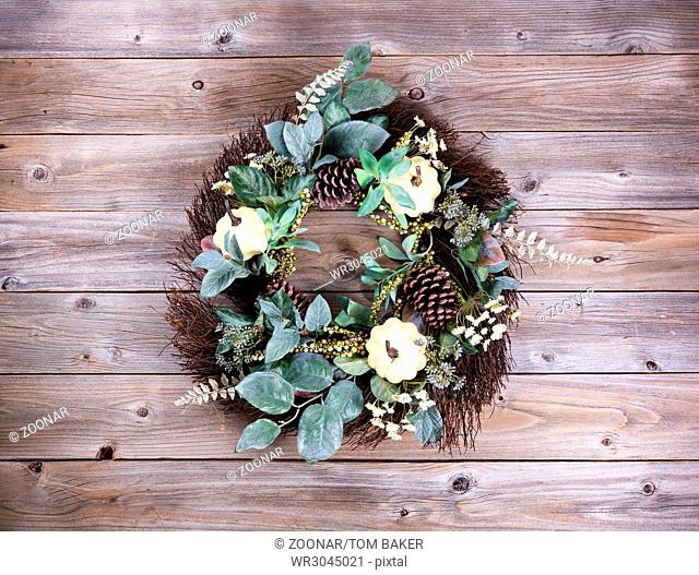 Autumn holiday wreath on rustic wooden boards