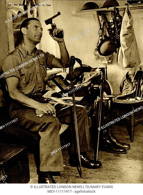 Soldier S.W. Saunders cleans out his revolver, with his ceremonial sword propped between his legs and army kit visible in the background