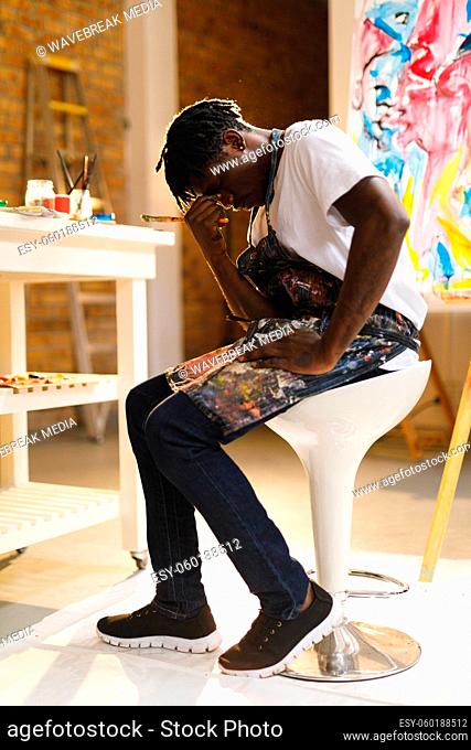 Tired african american male painter at work in art studio