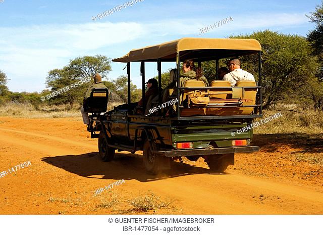 SUV with tourists and trackers on a field trip in the Madikwe Game Reserve, South Africa, Africa