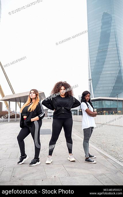 Three sportive young women posing in the city