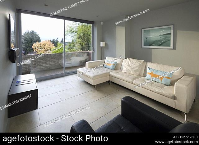 The living room area of a modern family home in open plan style, with a seating area