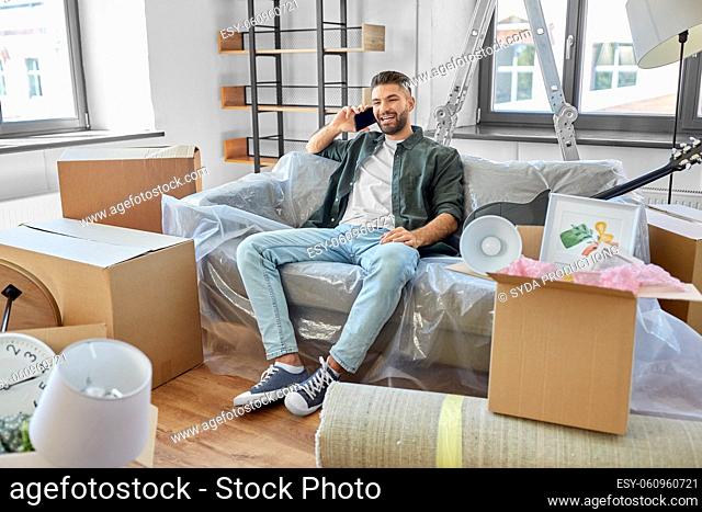 happy man calling on smartphone moving to new home