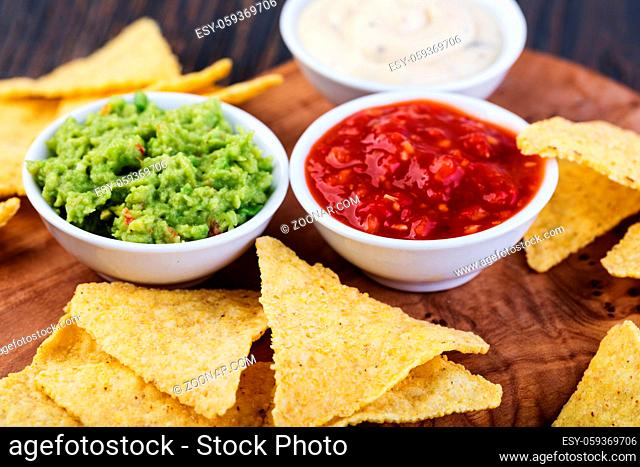 Corn chips nachos with sauce on a wooden table