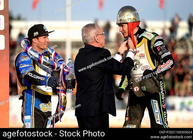 Jeweler Pavel Lejhanec, center, places the Golden Helmet to winner Patryk Dudek from Poland, right, during the Golden Helmet of Pardubice