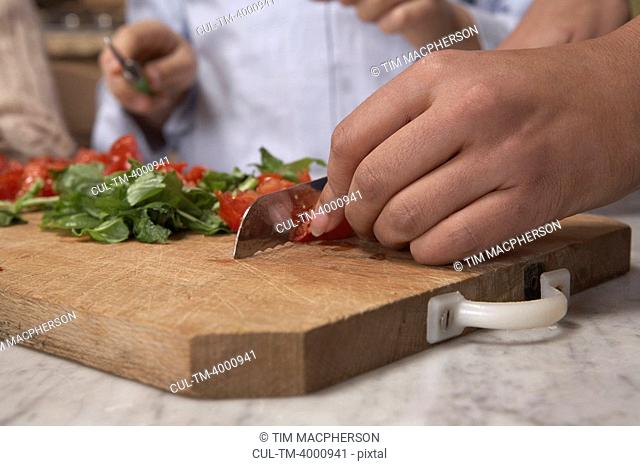 Woman chopping tomato's on board, close-up