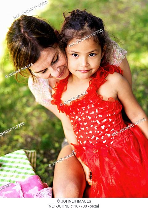Mother holding daughter wearing red dress