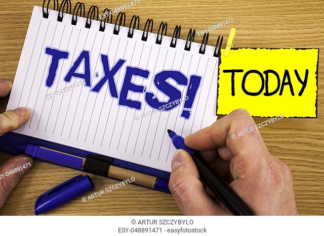 Word writing text Taxes Motivational Call. Business concept for Money demanded by a government for its support written by Marker in Hand Notebook wooden...