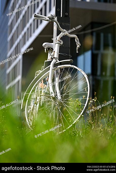PRODUCTION - 23 August 2023, Hesse, Frankfurt/Main: A ghost bike, a discarded bicycle painted white, on Europaallee in the Gallus district commemorates an...