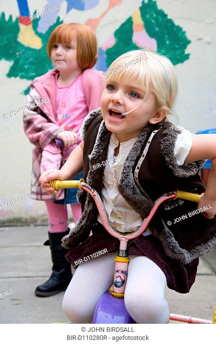 Little girl playing on a toy bike at breaktime