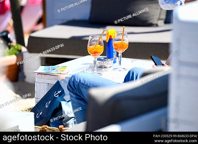 PRODUCTION - 29 May 2023, Schleswig-Holstein, Scharbeutz: Drinks stand on a table at the Beachlounge Scharbeutz on the Baltic Sea beach