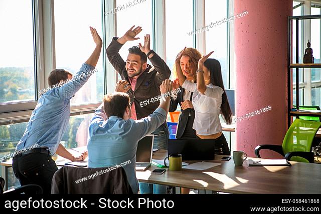Business people giving five after dealing and signing contract or agreement with partners abroad. Colleagues showing team work in office interior