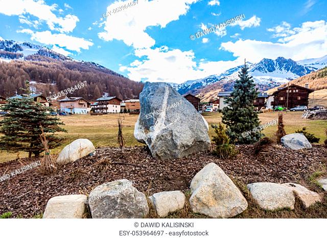 Stone circle with big boulder in the centre, mountain valley with Livingo village in background, Italy, Alps