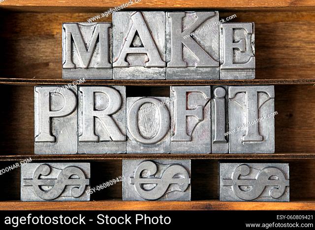 make profit phrase with dollar sign made from metallic letterpress type on wooden tray