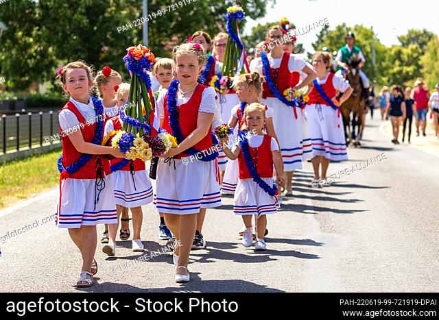 19 June 2022, Brandenburg, Casel: Riders, young women and girls from the Drebkauer district of Casel go to the fairground during the Johannisreiten after...