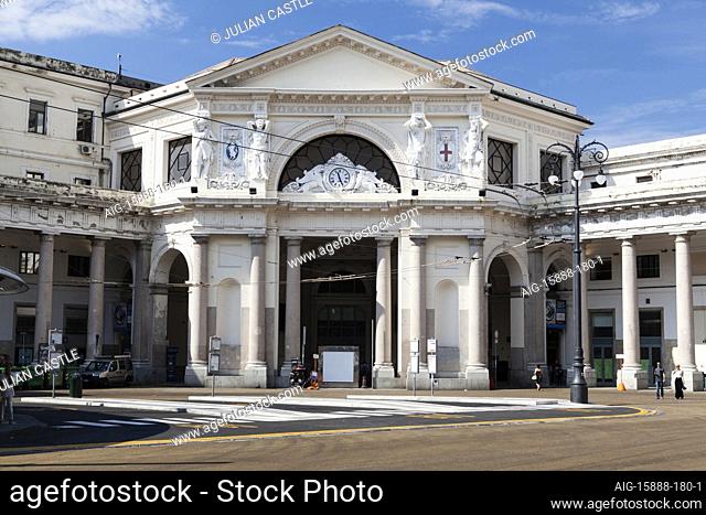 An exterior view of Piazza Principe railway station in Genoa. Designed by Alexander Mazzucchetti. People walking on the street