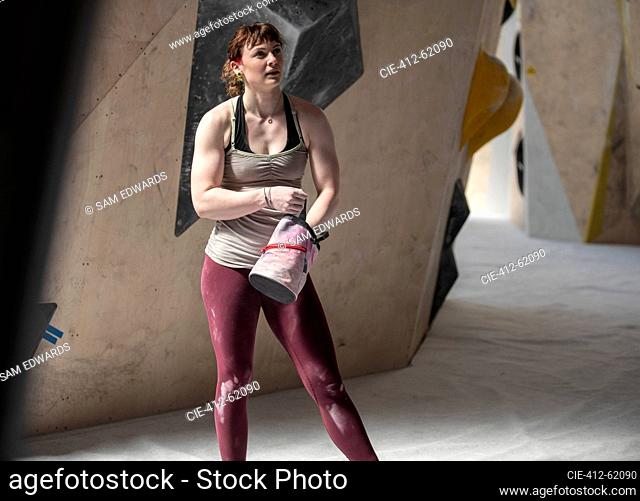 Young female rock climber with chalk bag